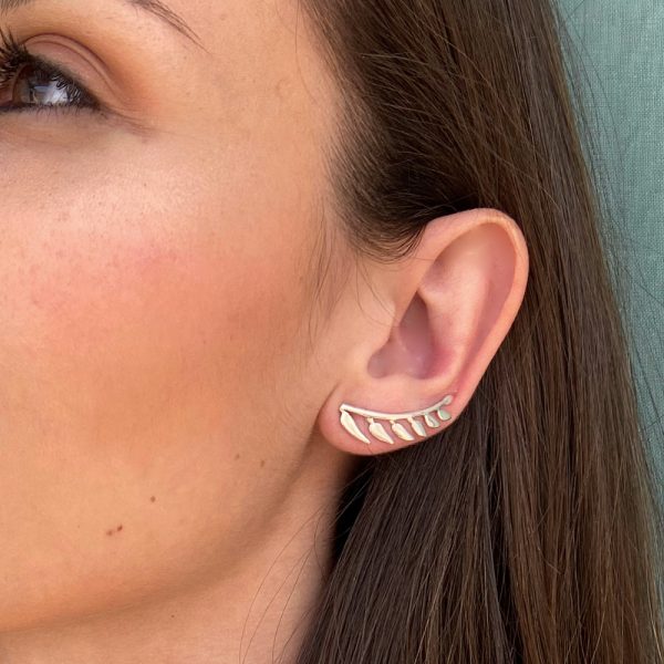 Pendientes de plata trepadores con forma de ramita de la que por un lado salen siete hojas, la ramita tiene forma curva para seguir la forma del lóbulo, quedando esta perfectamente integrada en la oreja.