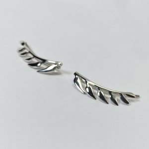 Pendientes trepadores con forma de ramita de la que por un lado salen seis hojas, la ramita tiene forma curva para seguir la forma del lóbulo, quedando esta perfectamente integrada en la oreja.