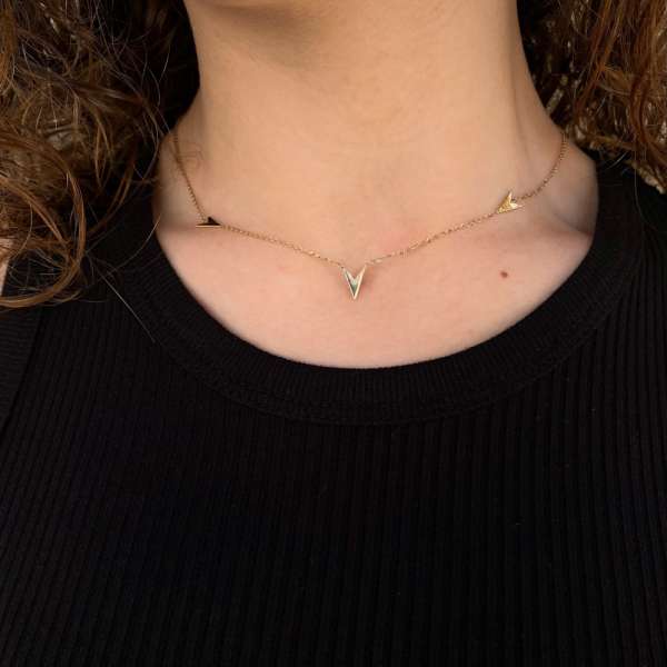 Gargantilla de oro amarillo con cadena fina y tres motivos sencillos, para llevar a diario.